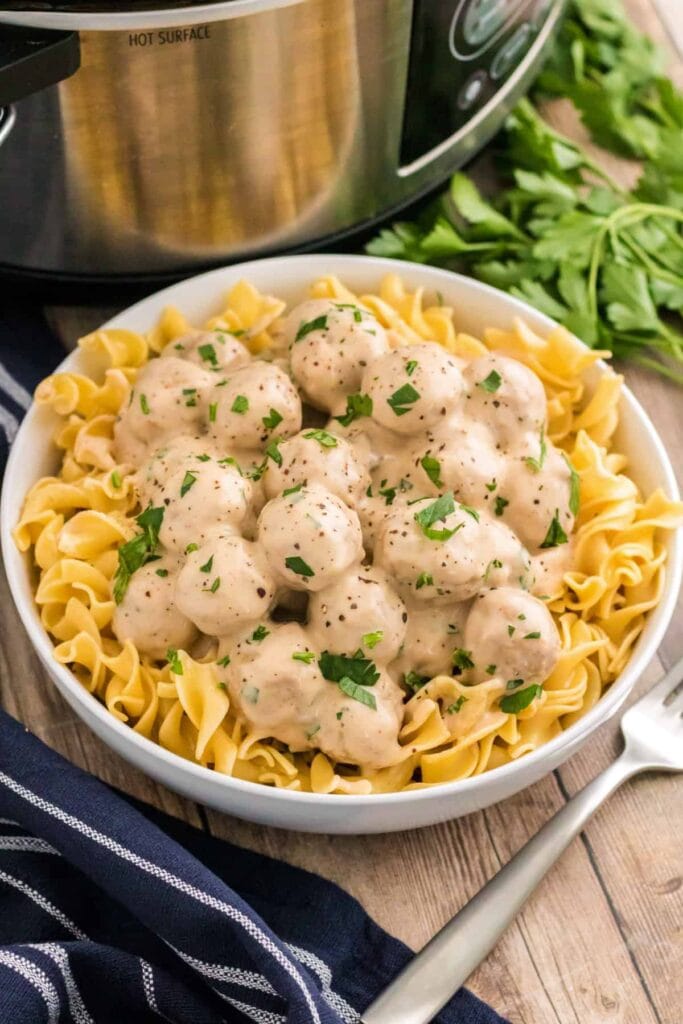 Slow cooker Swedish meatballs with pasta in a bowl.