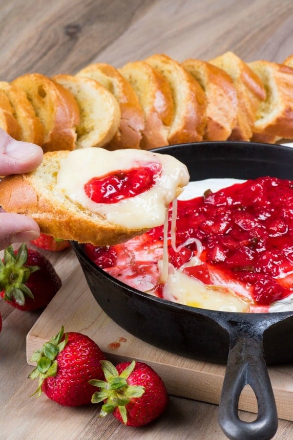 Strawberry jalapeño brie in a skillet with toasted bread.