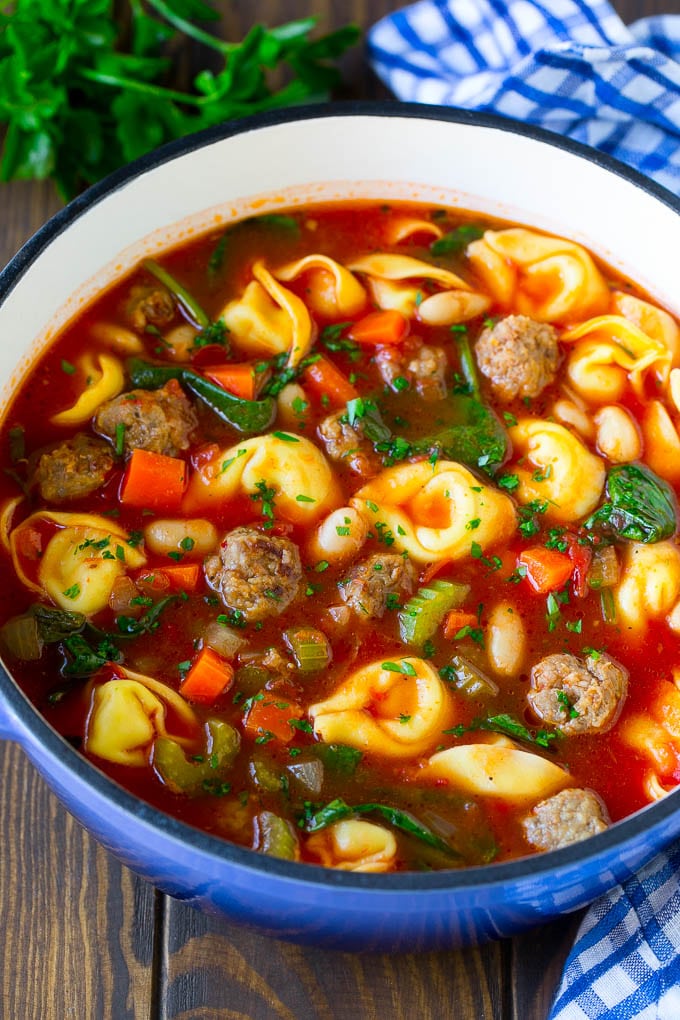 Tortellini soup with sausage in a pot.