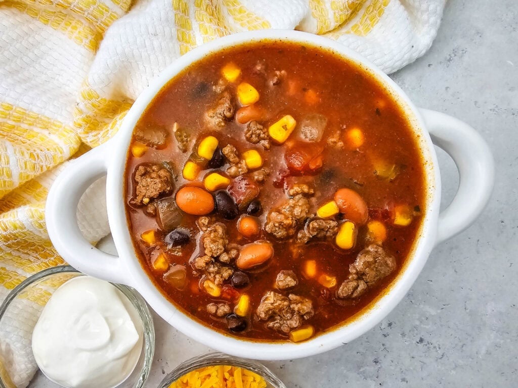 Overhead view of 7 Can Taco Soup with Ground Beef served in a white bowl.