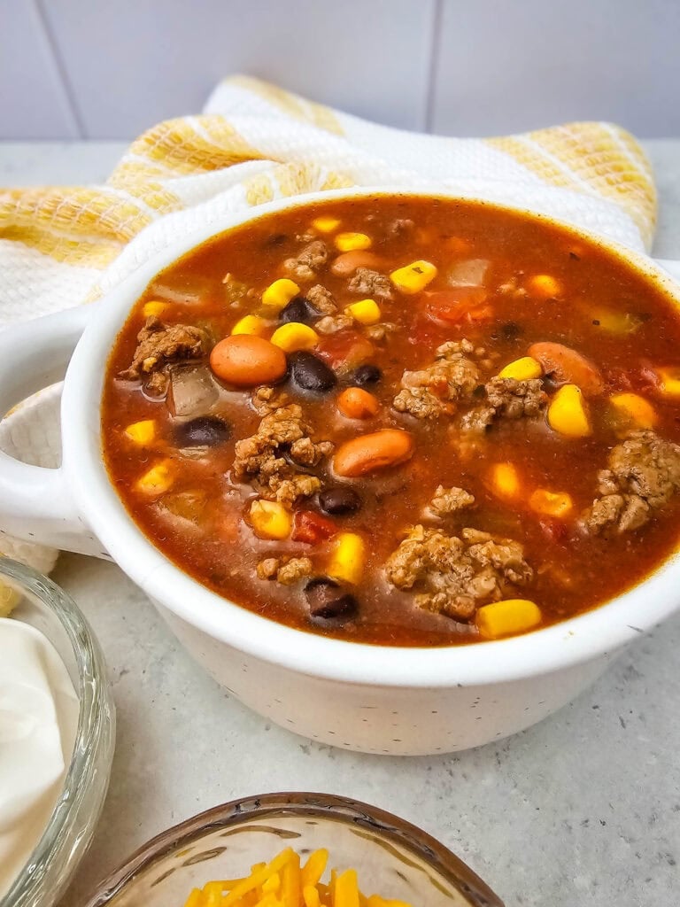 7 Can Taco Soup with Ground Beef served in a white bowl.