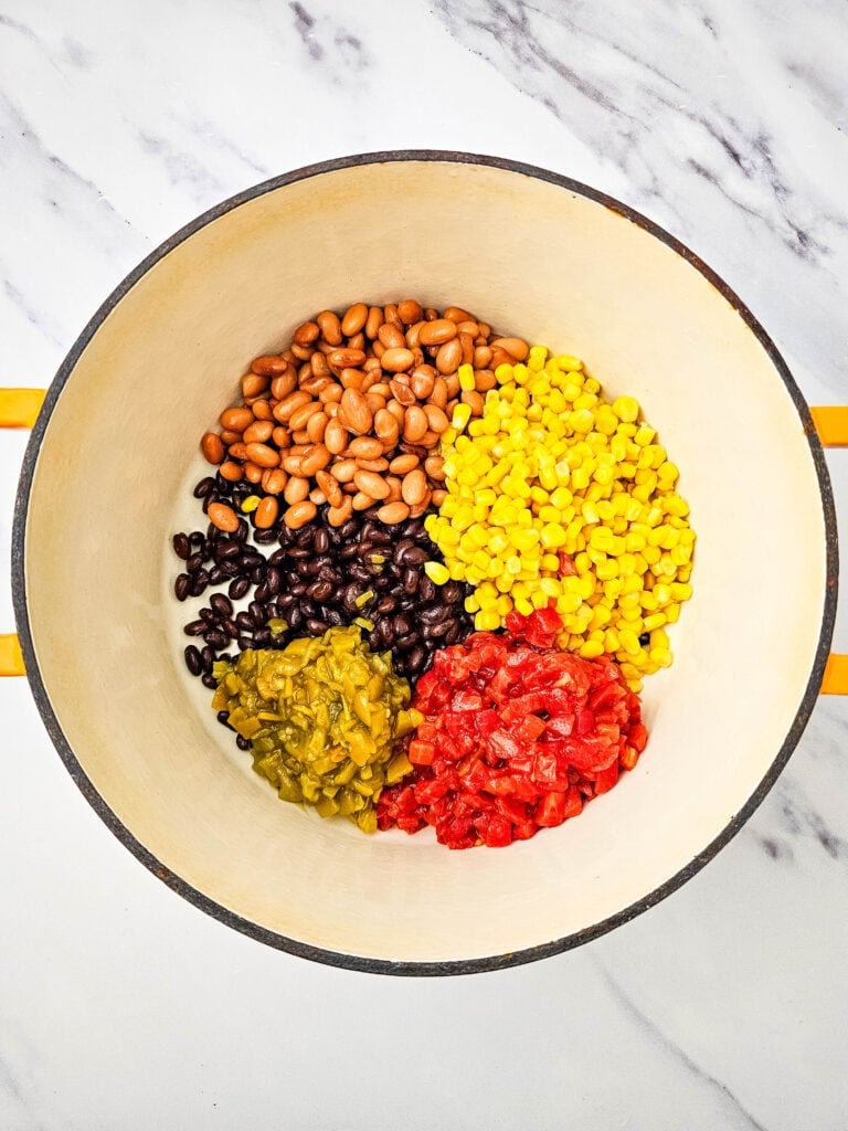 Beans, corn, tomatoes, chiles, and seasonings in a pot