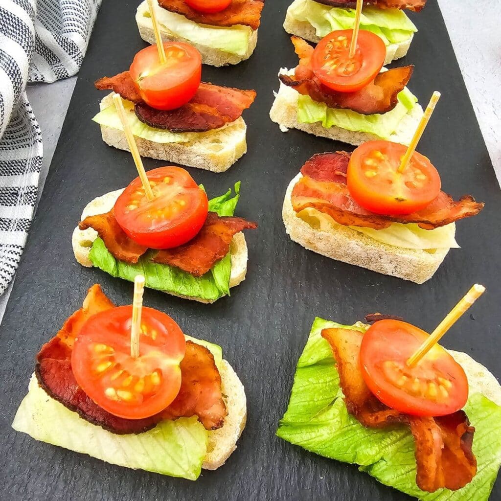 BLT bites on a black slate plate.