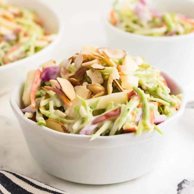 Broccoli slaw with sliced nuts in a bowl.