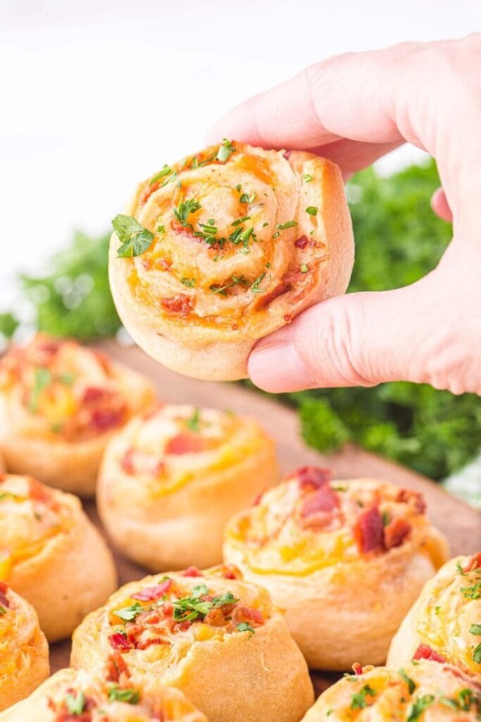 Cheddar bacon pinwheel held in a hand.