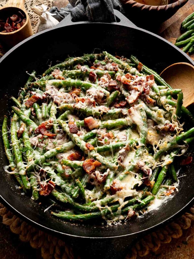 Cheesy green beans in a skillet.