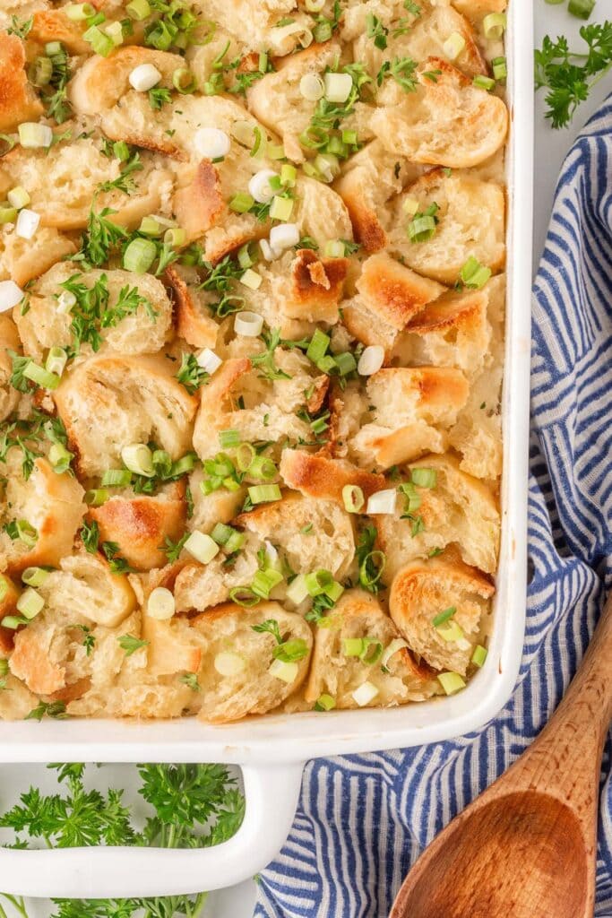 Chicken casserole in a baking dish topped with bread and green onions.