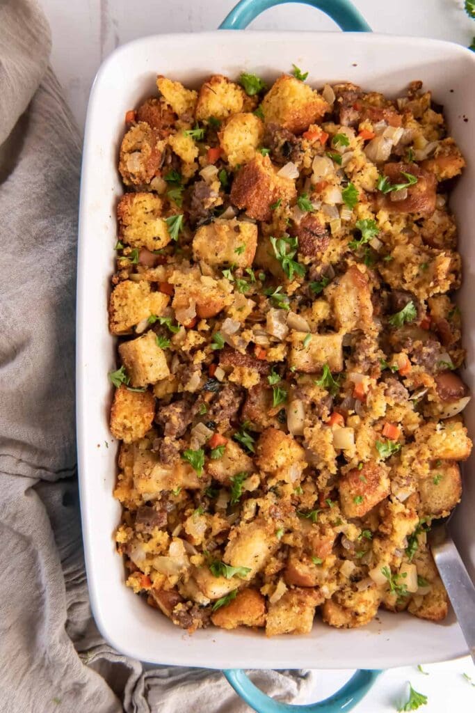 Cornbread stuffing with sage sausage and apples in a baking dish.