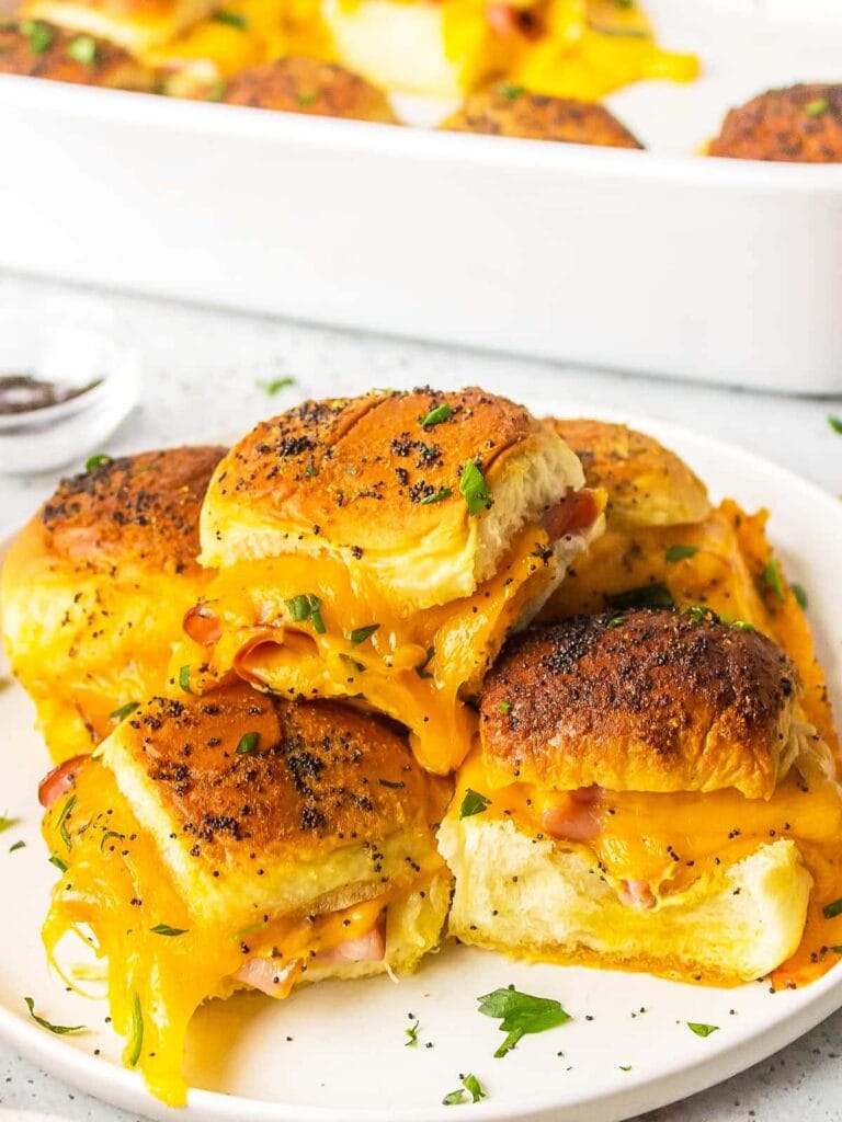 Ham and cheese sliders on a plate.