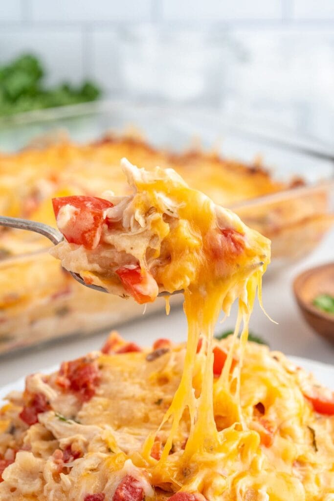 King Ranch chicken casserole on a spoon with melted cheese.