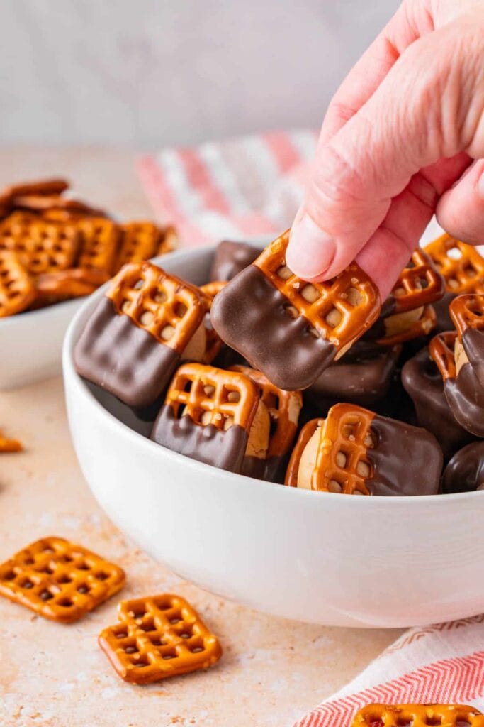 Peanut butter pretzel bites with chocolate coating in a bowl.