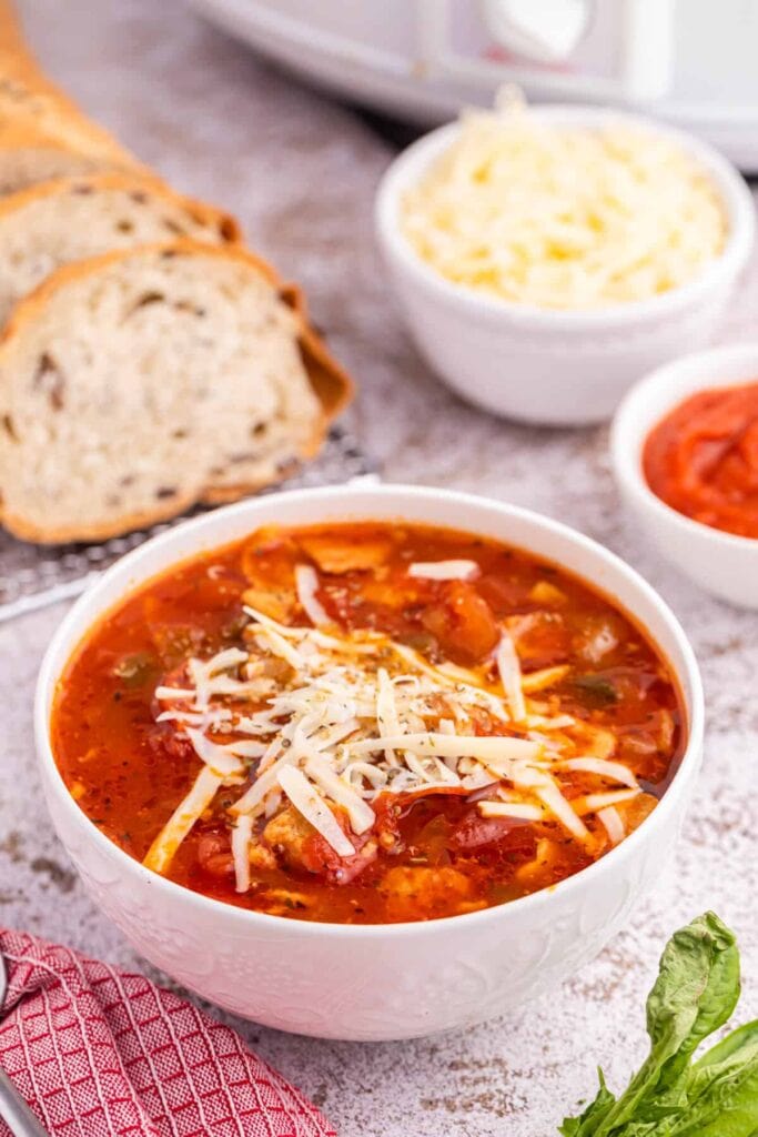 Pizza soup topped with cheese in a bowl.