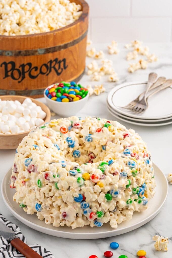 Popcorn cake with colorful candy and marshmallows in a bowl.