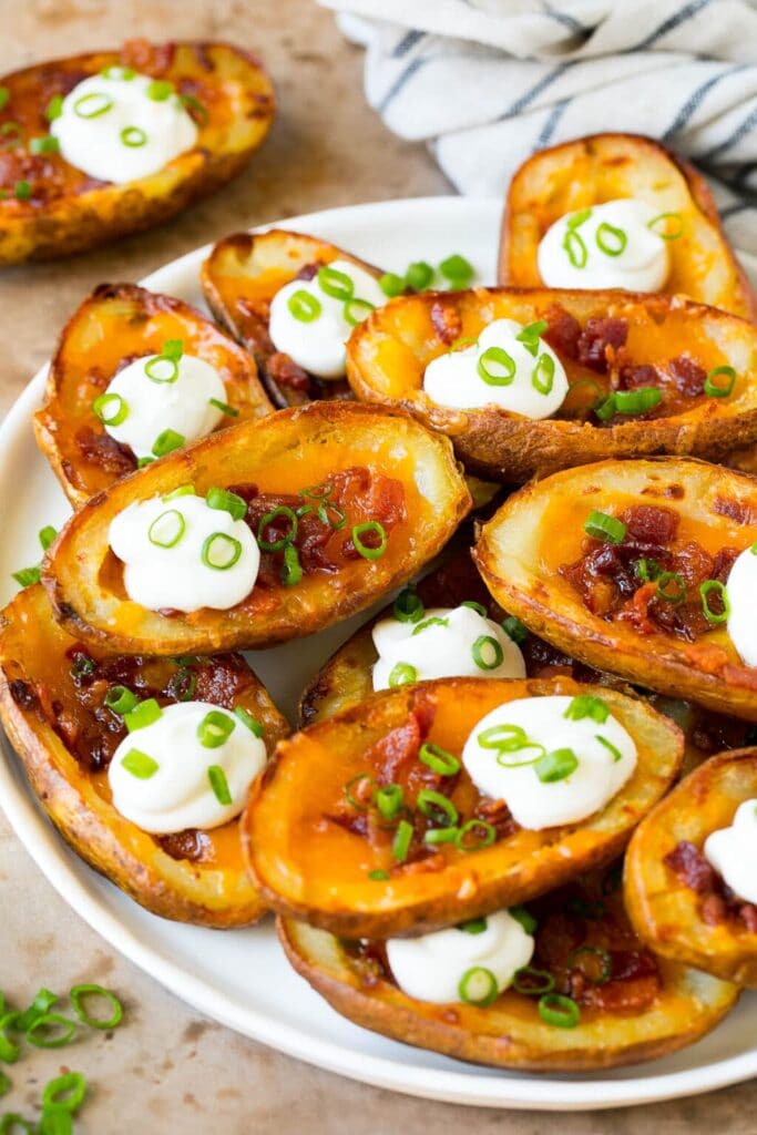 Potato skins with cheese, bacon, and sour cream on a plate.