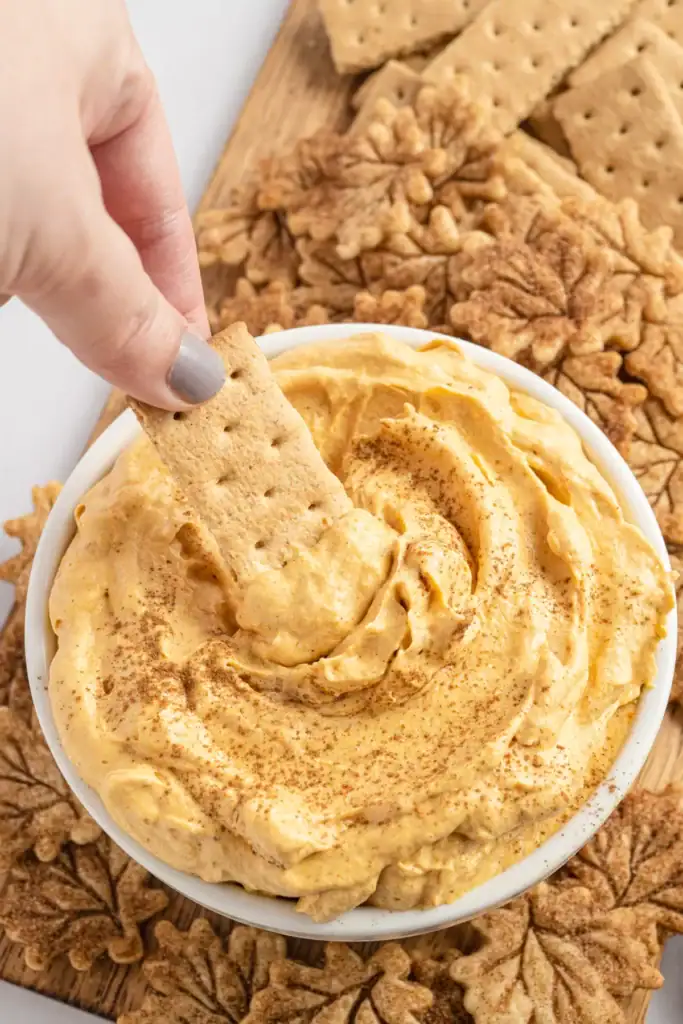 Pumpkin pie dip with a graham cracker for dipping.
