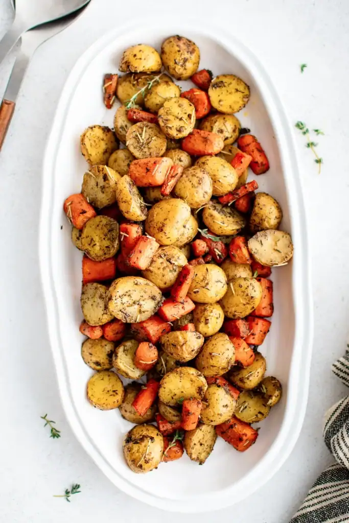 Roasted potatoes and carrots in a serving dish.
