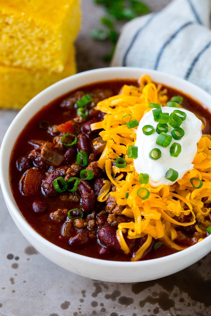Slow cooker chili with cheese and sour cream in a bowl.