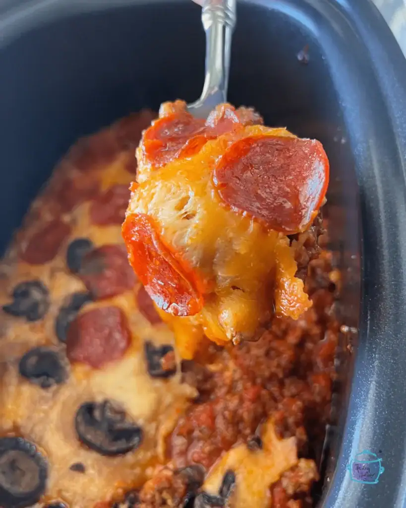Slow cooker crustless pizza casserole on a spoon.