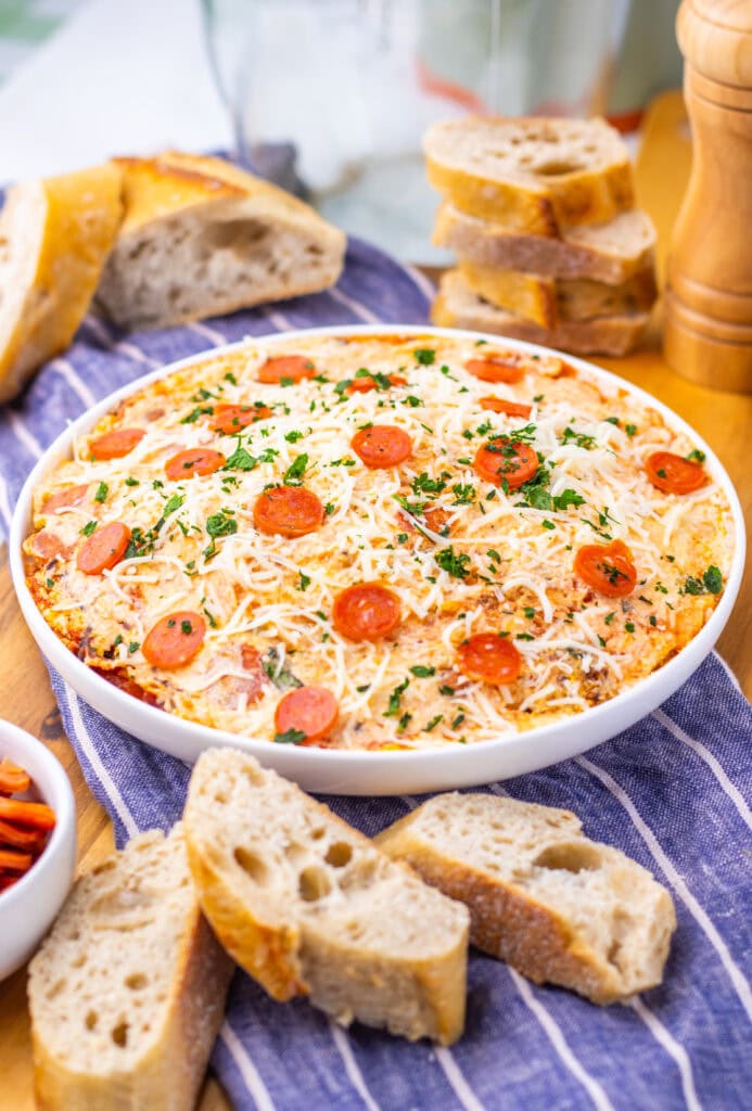 Slow cooker pizza dip with sliced bread.