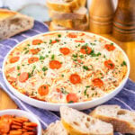 Slow cooker pizza dip served with sliced bread.