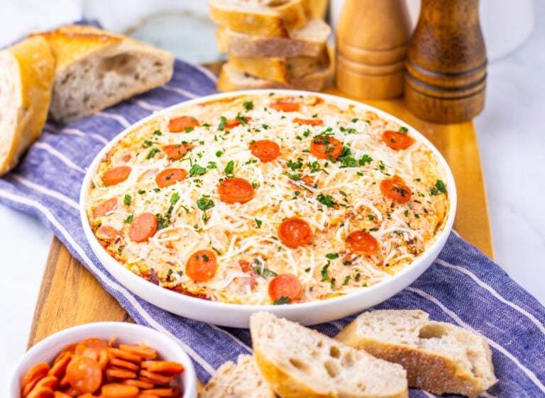 Slow cooker pizza dip served with sliced bread.