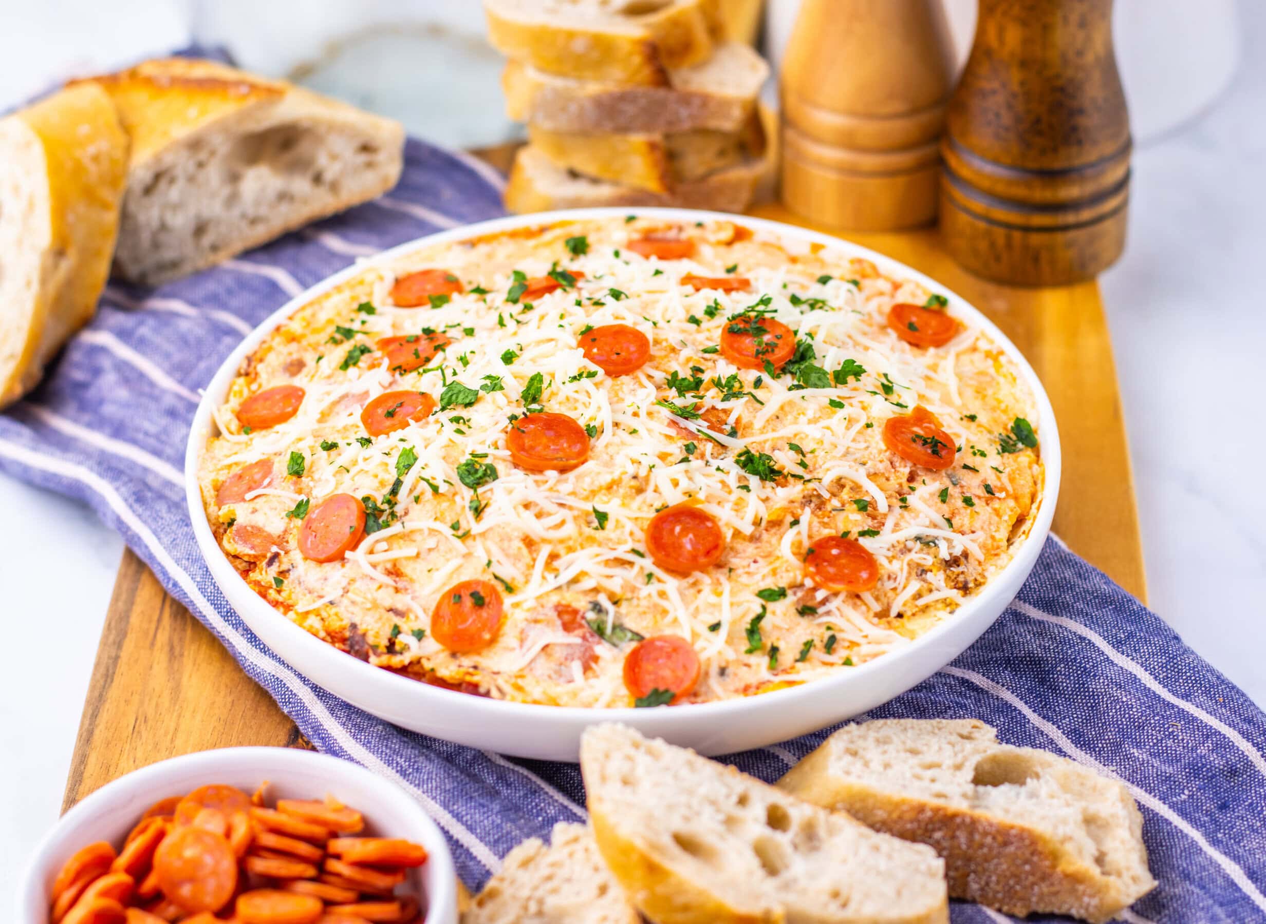 Slow cooker pizza dip served with sliced bread.