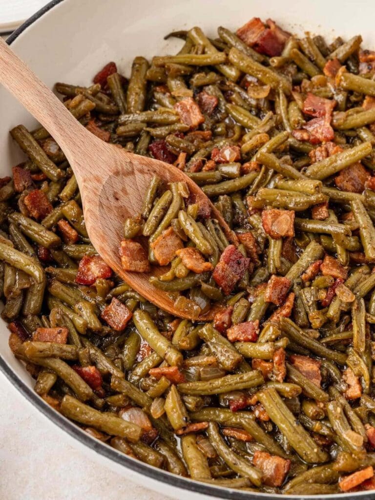 Smothered green beans with bacon in a skillet.