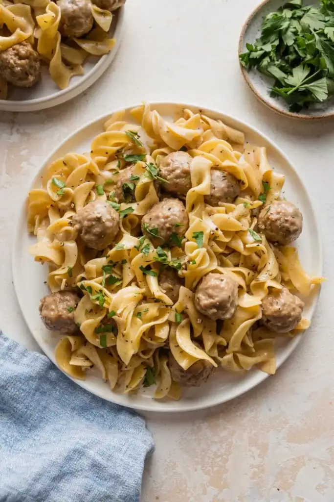 Swedish meatballs with egg noodles on a plate.