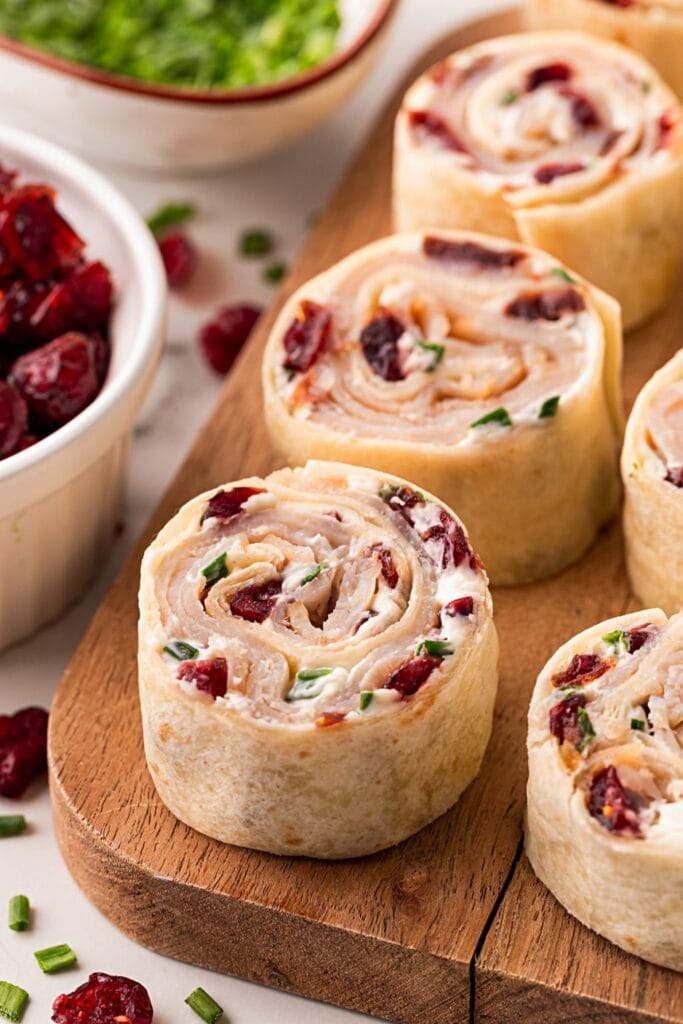 Turkey cranberry pinwheels on a wooden board.