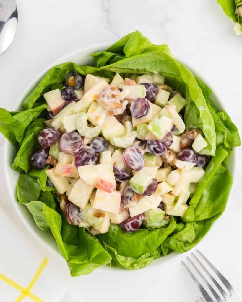 Waldorf salad with apples and grapes on a bed of lettuce.