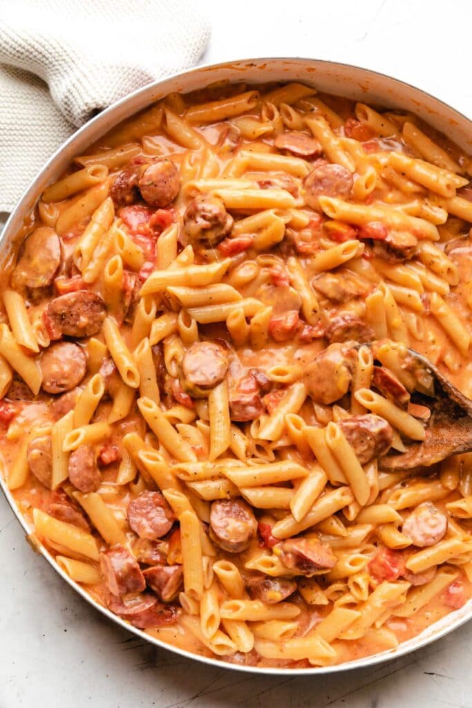 Cheesy kielbasa pasta in a skillet.