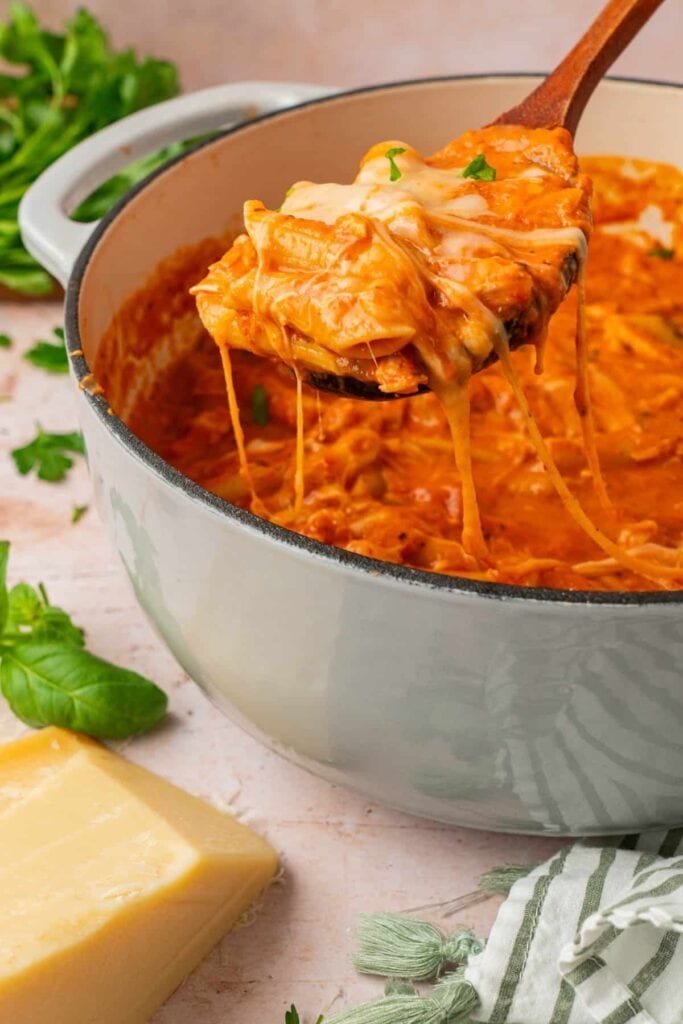 Close-up of chicken Parmesan soup on a wooden spoon.