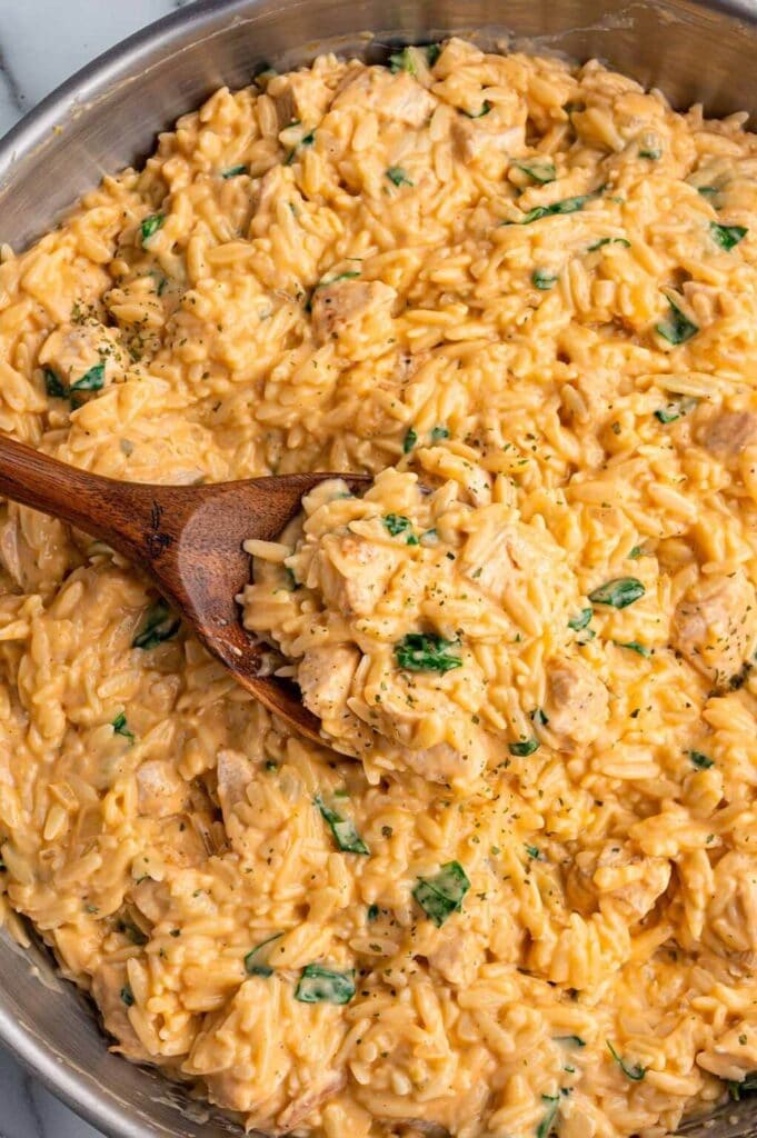 Creamy chicken orzo on a wooden spoon.
