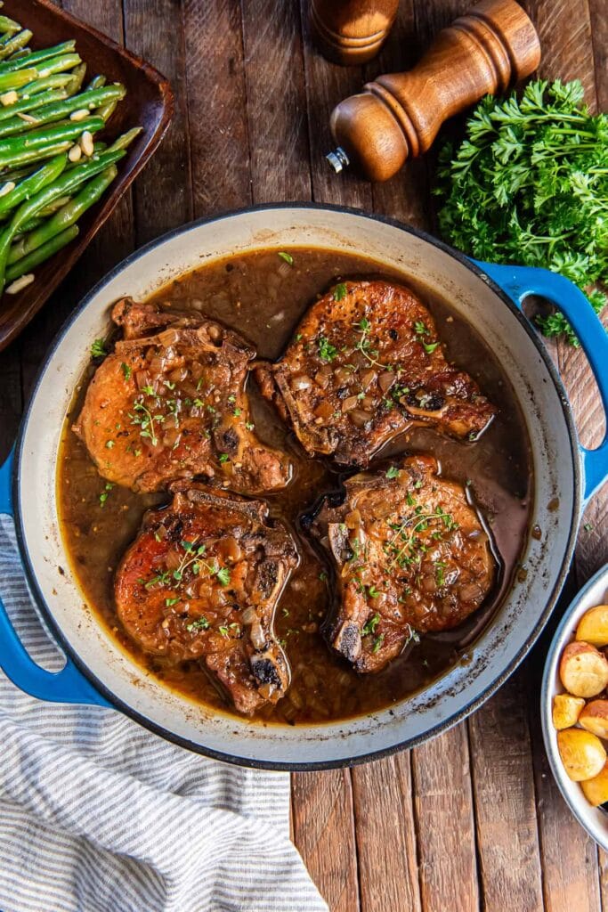 Skillet braised pork chops in a pot.
